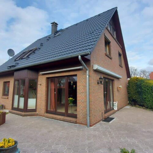 Einfamilienhaus nach Dachreinigung und Dachversiegelung. Dunkle Dachpfannen